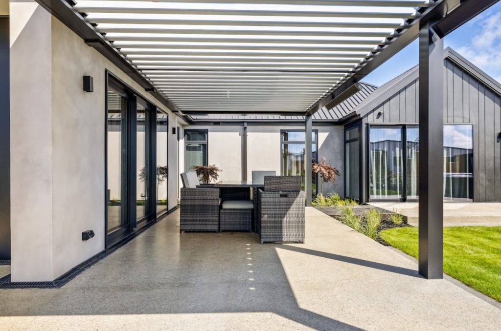 Hallmark Homes Oakbridge outdoor living area with pergola and alfresco dining at sunset - Christchurch custom home design and build