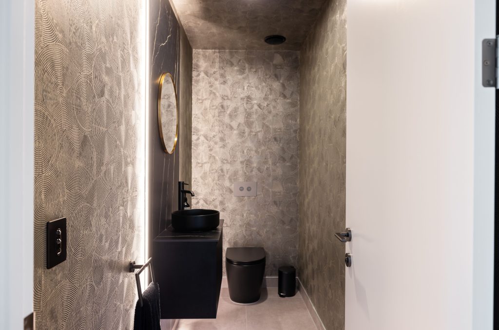 Deisgner wallpaper featured in Hallmark Home bespoke build in Christchurch. LED backlit black marble top paired with black accessories.