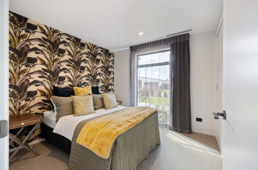 Hallmark Homes Oakbridge bedroom with tropical wallpaper feature wall and designer furnishings - Christchurch prestige home interiors