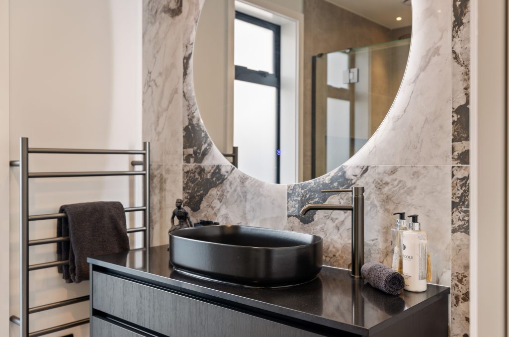 Luxury bathroom in Oakbridge home by Hallmark Homes Christchurch design and build with striking marble feature walls, modern basin, and premium fixtures