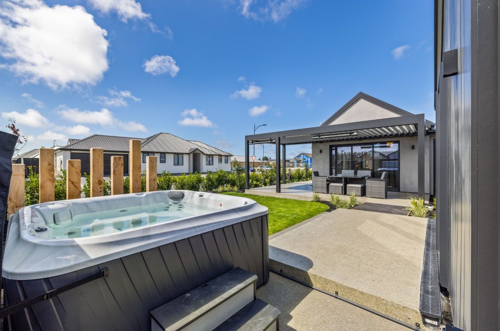 Rear view of the Hallmark Series Oakbridge home, combining architectural form and function with a sleek pergola, gabled rooflines, and stylish outdoor entertaining area.