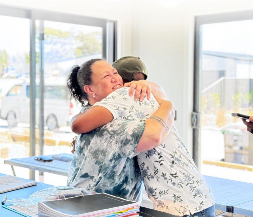 Hallmark Homes clients hugging a staff member at handover.